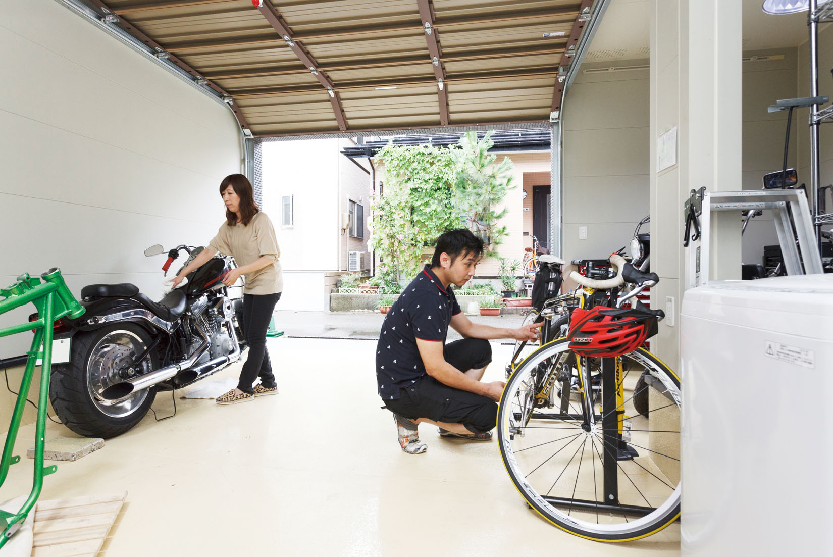 インナーガレージの注文住宅でバイクを整備する夫婦